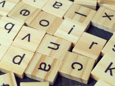 Alphabet letters on wooden scrabble pieces, close up