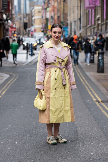 Andreea Cristea wears a JW Pei bag, Gucci trainers and a Warehouse trench coat during London Fashion...