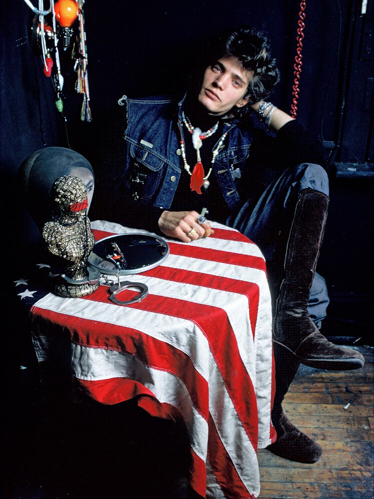 Robert Mapplethorpe in 1971 posing in a denim vest and black boots 