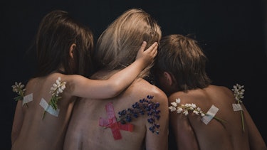 Children with their back to us wear flowers as wings