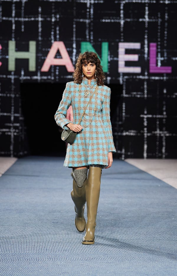 a model wearing green over-the-knee rain boots on the Chanel runway