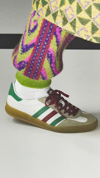 a model wearing white striped adidas sneakers on the Gucci runway