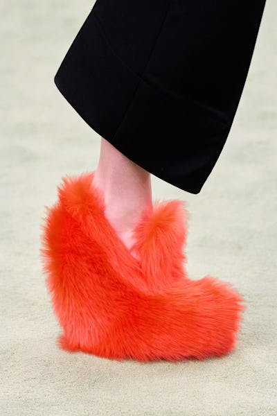 a model wearing bright orange fuzzy platform loafers on the Bottega Veneta runway