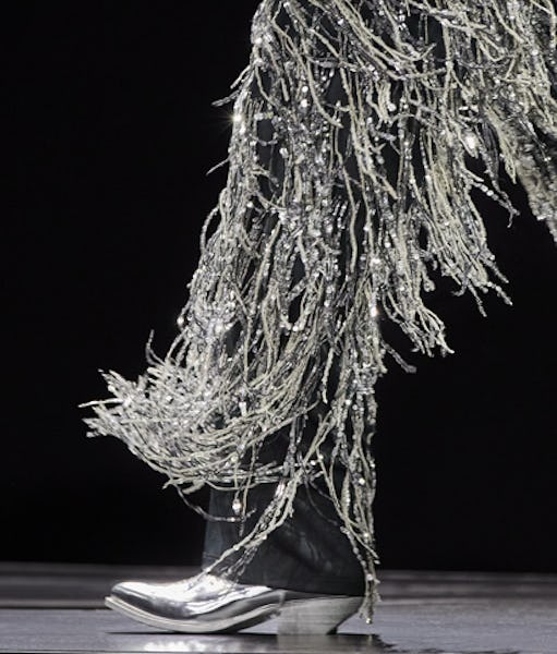 a model wearing silver cowboy boots on the Celine runway