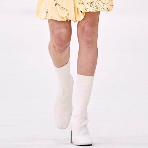 a model wearing white woven second-skin mid-calf boots on the Jil Sander runway