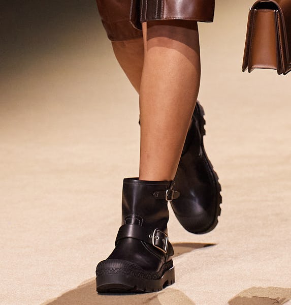 a model wearing black leather ankle moto boots on the Coach runway