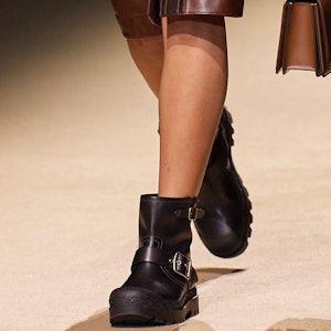 a model wearing black leather ankle moto boots on the Coach runway