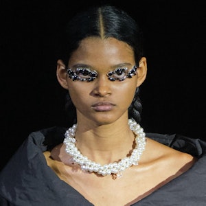 a model wearing a large twisted pearl necklace on the Simone Rocha runway