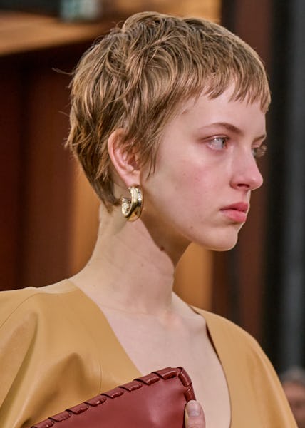 a model wearing thick gold hoop earrings on the Chloé runway