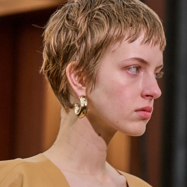 a model wearing thick gold hoop earrings on the Chloé runway