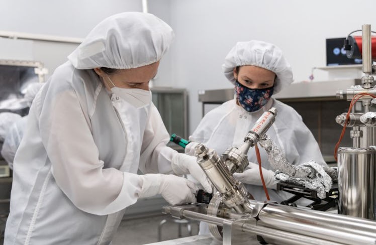 scientists in cleanroom gear work on a lunar sample