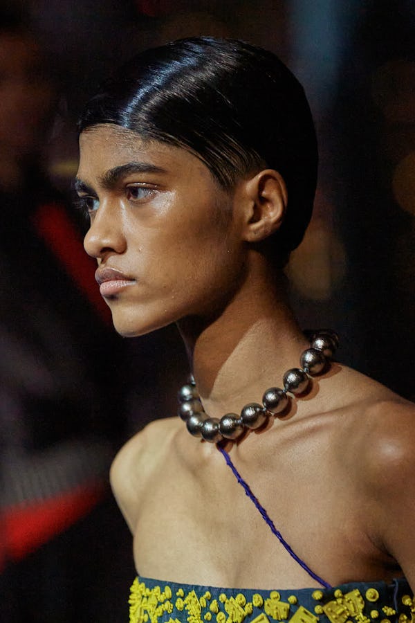 a model wearing a thick silver ball chain necklace on the Tory Burch runway