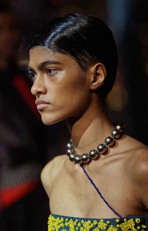 a model wearing a thick silver ball chain necklace on the Tory Burch runway