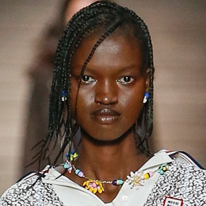 a model wearing a beaded necklace on the Miu Miu runway