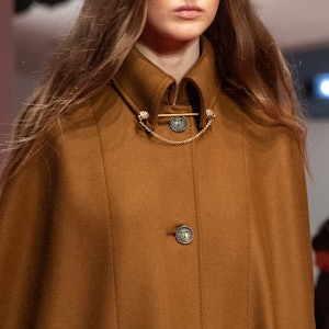 a model wearing a yellow gold collar chain on the Tod's runway