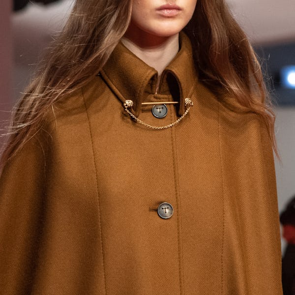 a model wearing a yellow gold collar chain on the Tod's runway
