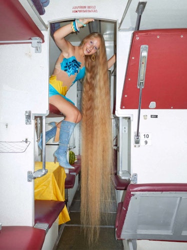 A person with very long hair on a Ukrainian train photographed by Julie Poly in a blue-yellow outfit