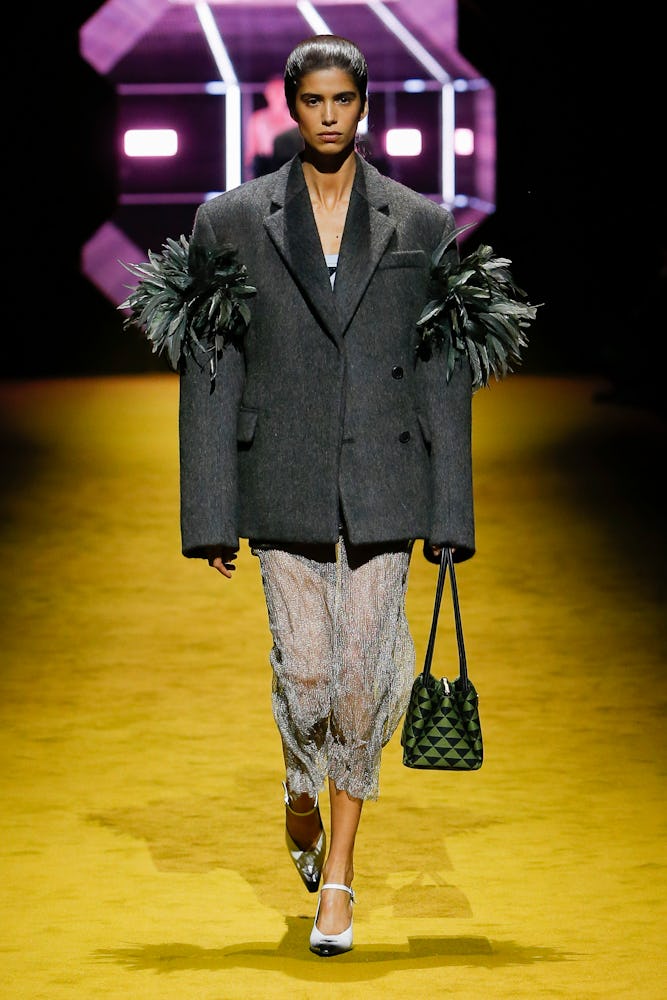 a model wearing a grey blazer and sheer beaded skirt on the Prada runway