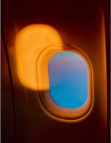 A yellow and blue airplane window photographed by Peter Langer