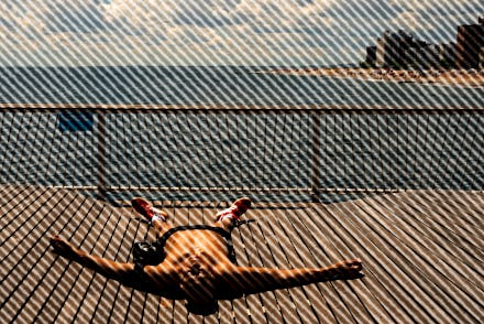 A person sunbathes on the boardwalk at Coney Island beach in New York City on July 4, 2021 .