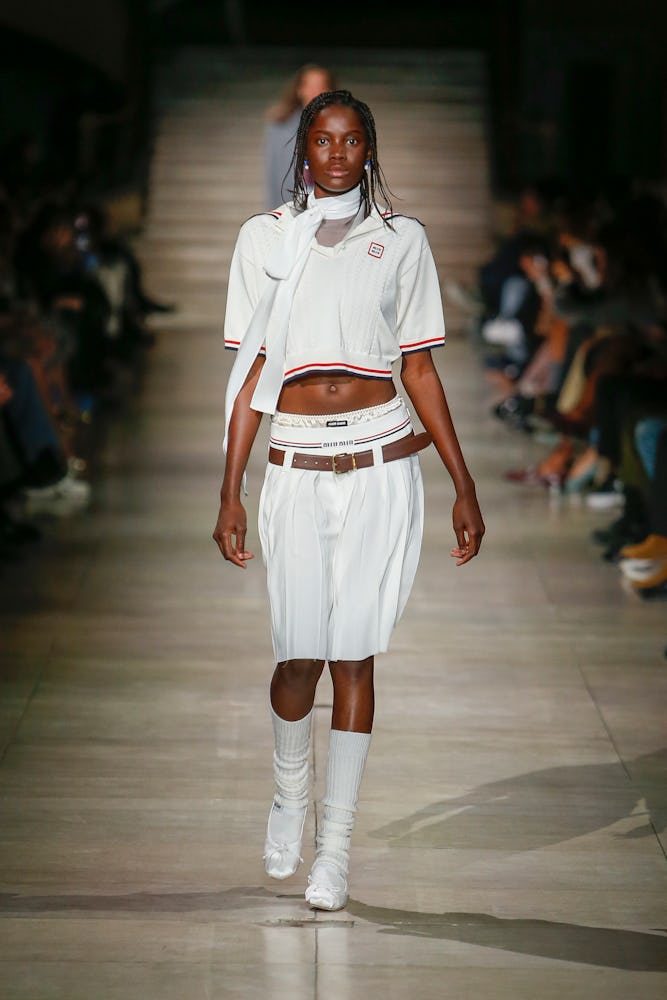 model wearing white pleated skirt on fall winter 2022 miu miu runway