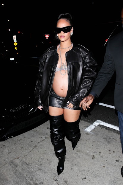 Rihanna wears black leather jacket, mini skirt, and thigh-high boots, with sparkly bra top.
