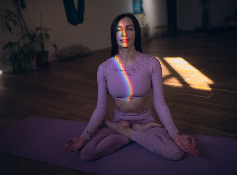 Young woman meditating at home on March 18, making her dreams a reality during the full worm moon in...