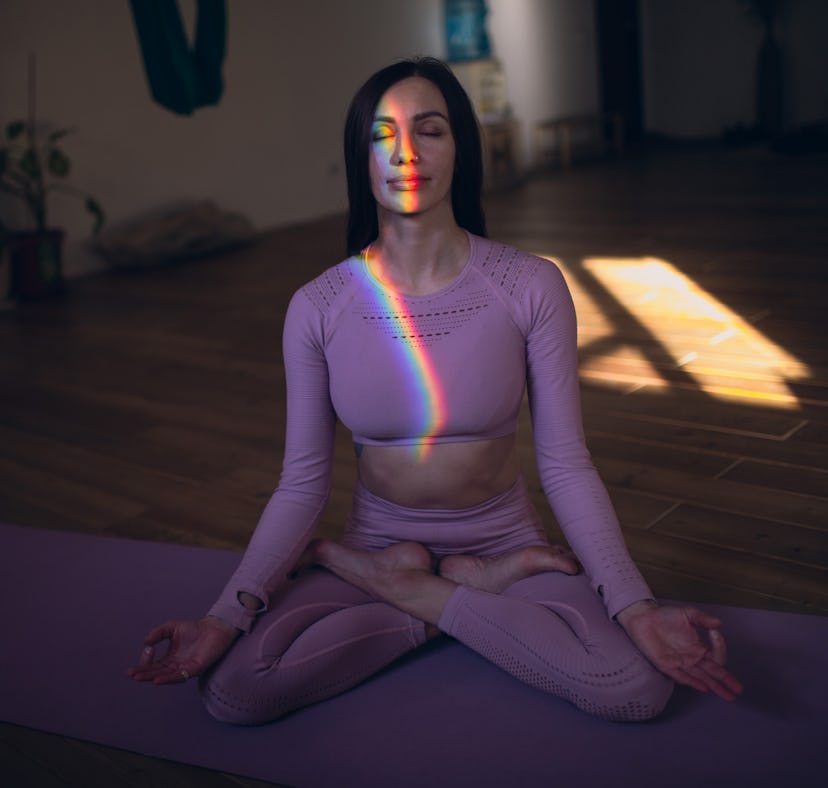 Young woman meditating at home on March 18, making her dreams a reality during the full worm moon in...
