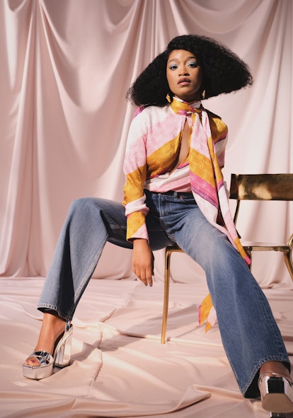 Keke Palmer in a light pink Fendi shirt with stripes of white and yellow, Valentino jeans, Faris ear...