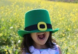 happy kid wearing leprechaun hat in article about st. patrick's day riddles