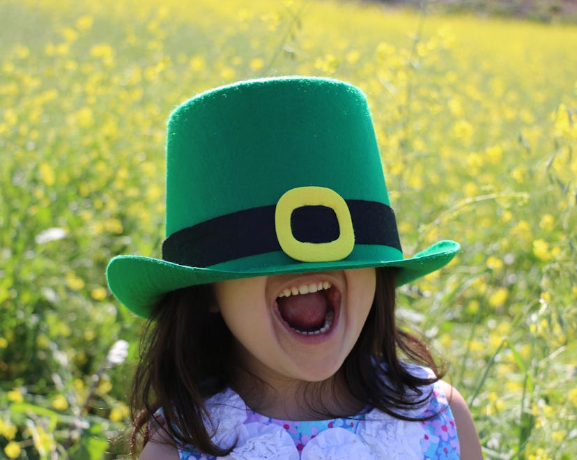 happy kid wearing leprechaun hat in article about st. patrick's day riddles