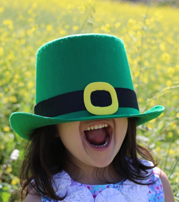 happy kid wearing leprechaun hat in article about st. patrick's day riddles