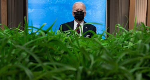 President Biden listens during a climate change virtual summit from the East Room of the White House...