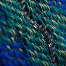 A closeup of blue and green knitted fibers of a fabric.