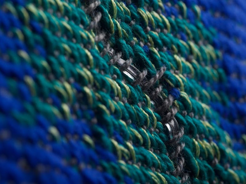 A closeup of blue and green knitted fibers of a fabric.