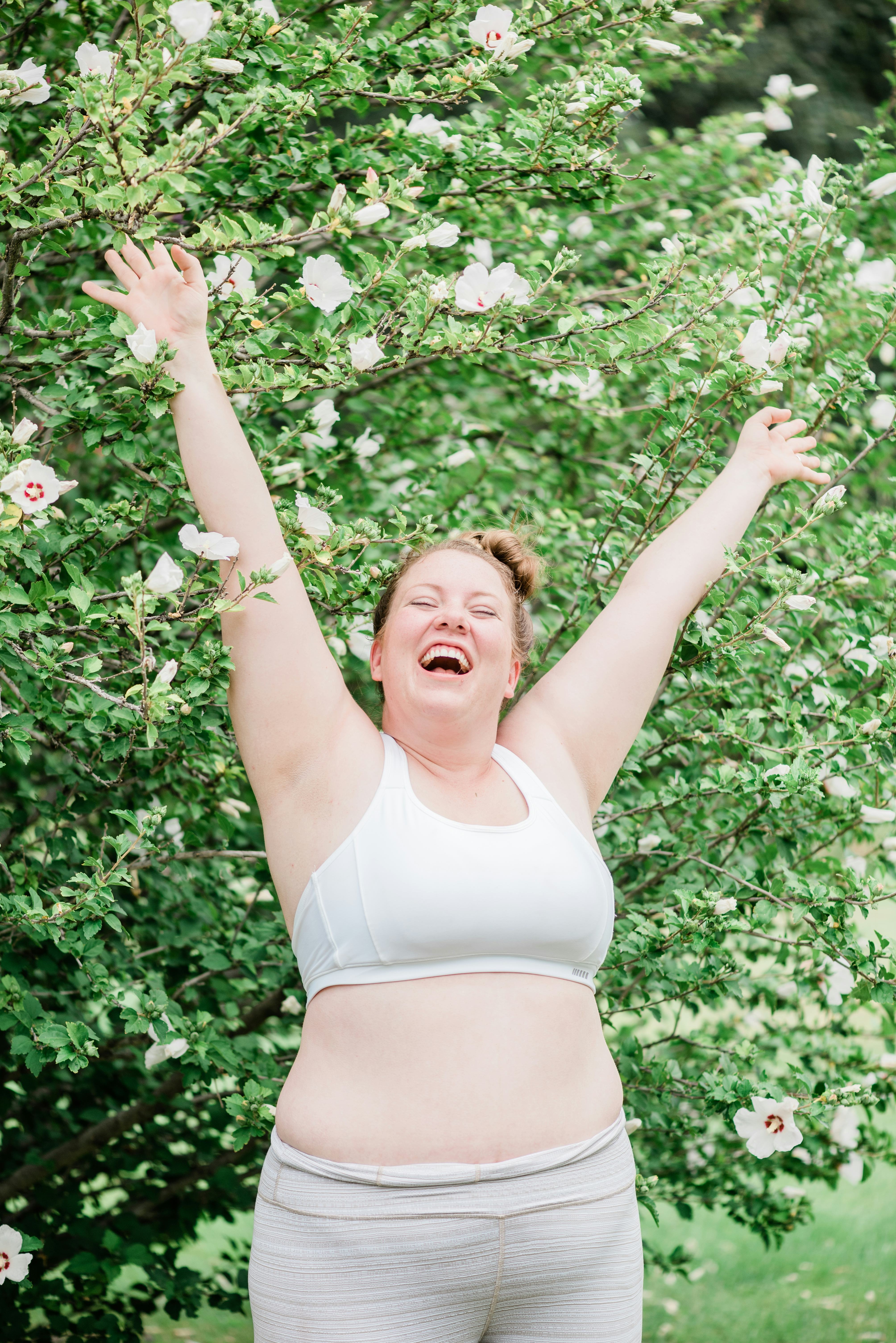 Happy young woman with her arms in the air after reading the spring equinox 2022 horoscope for her z...