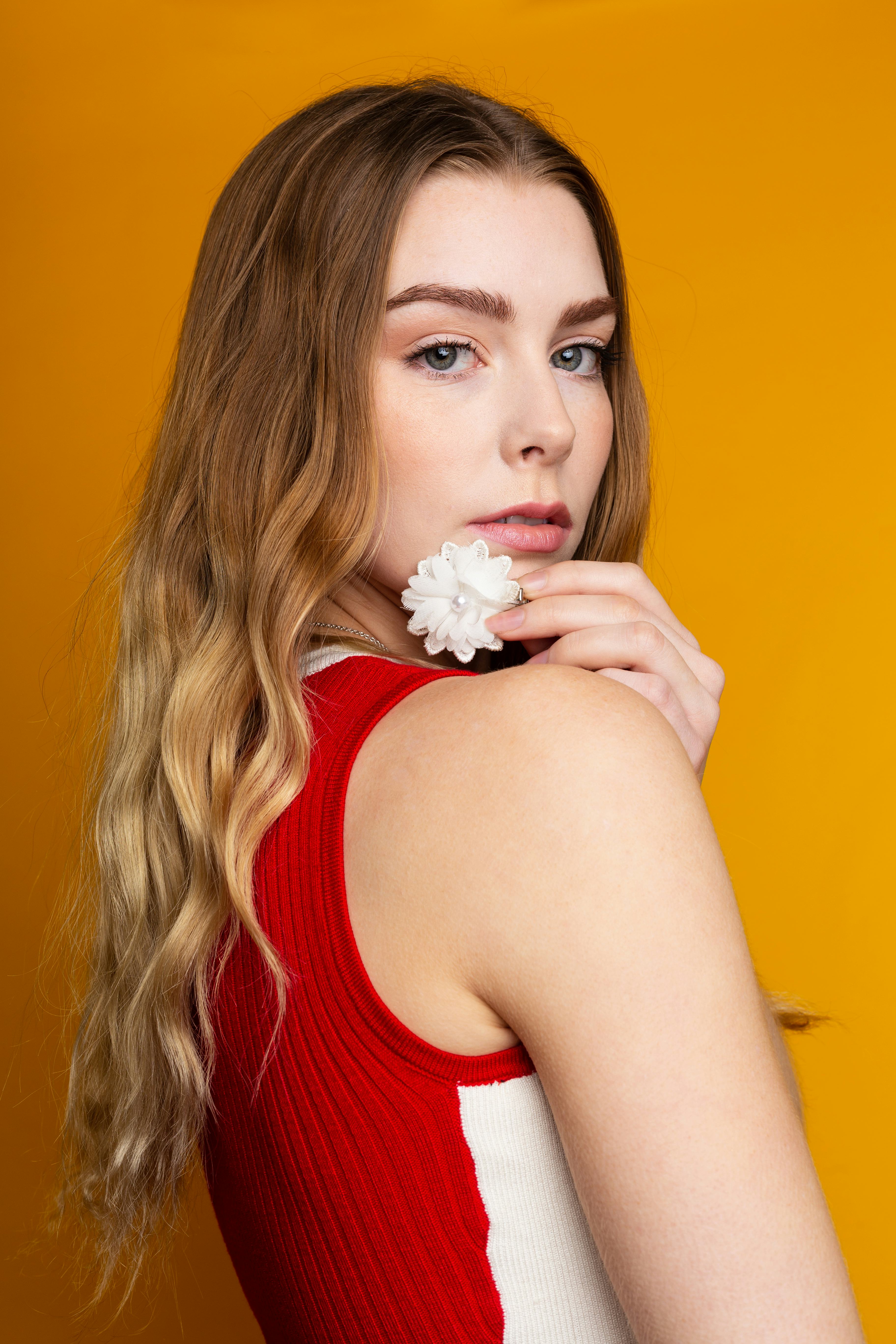 Young woman holding a flower to kickstart her astrological new year 2022 horoscope.