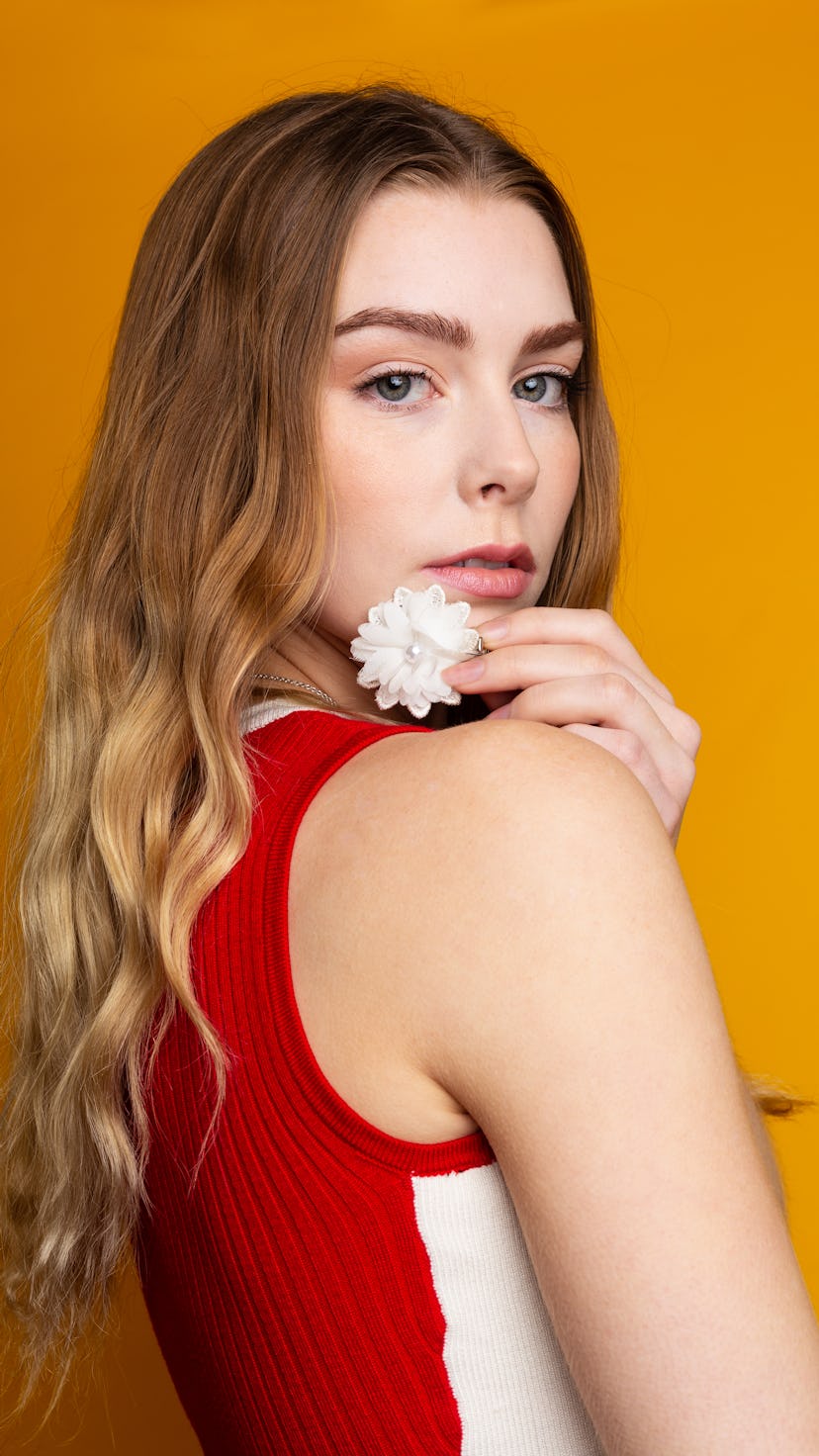 Young woman holding a flower to kickstart her astrological new year 2022 horoscope.
