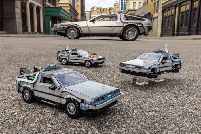 Lego's three DeLoreans in front of the DeLorean from the movies.