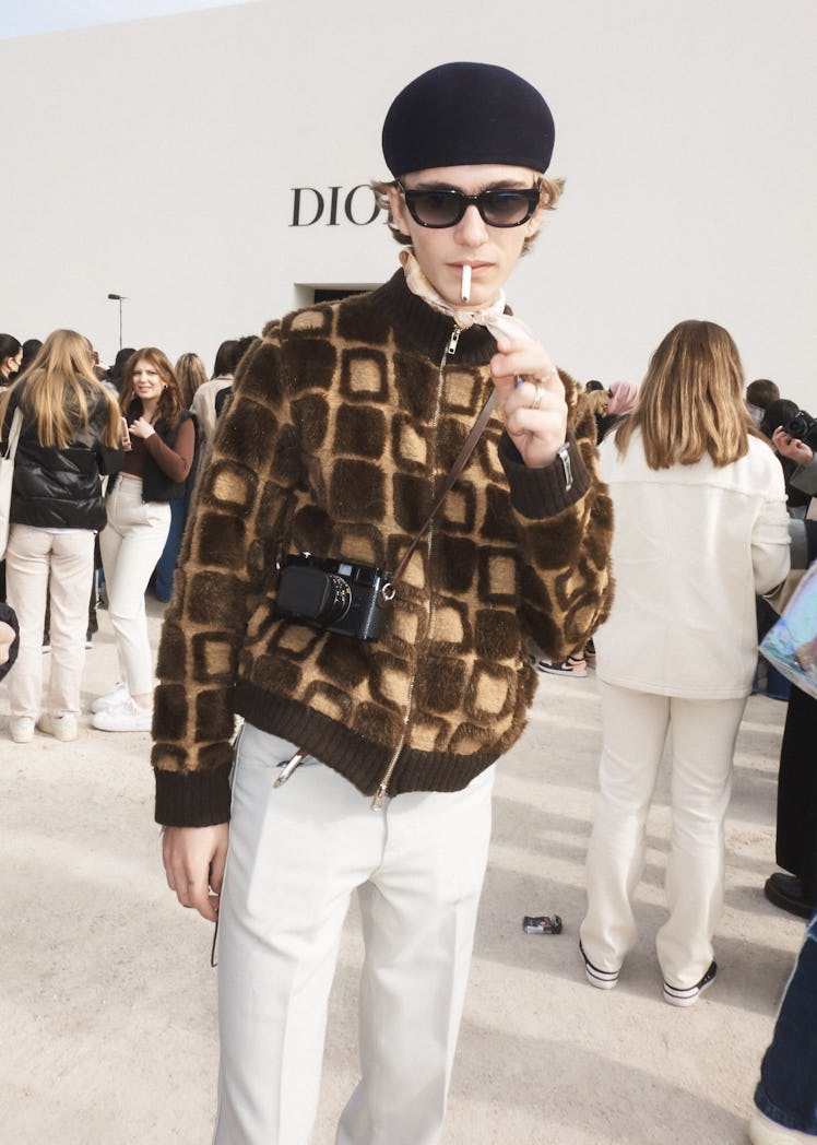 A person smoking outside the Dior fall 2022 show