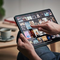 Man scrolling through Netflix on an iPad.