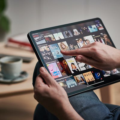 Man scrolling through Netflix on an iPad.