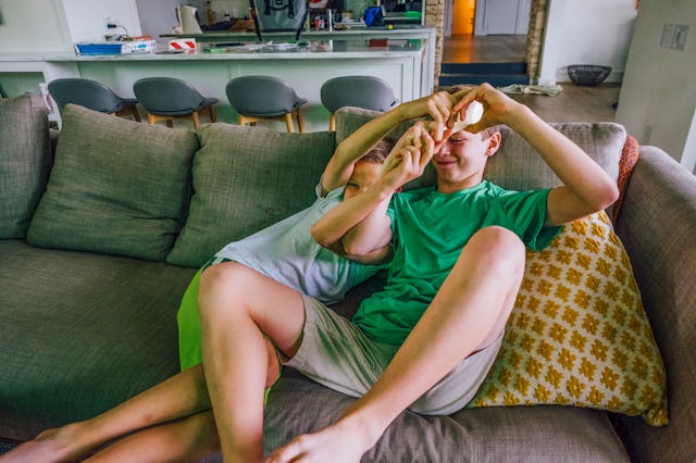 A boy in a green shirt and grey shorts and a girl in a light blue shirt and green skirt playing on a...