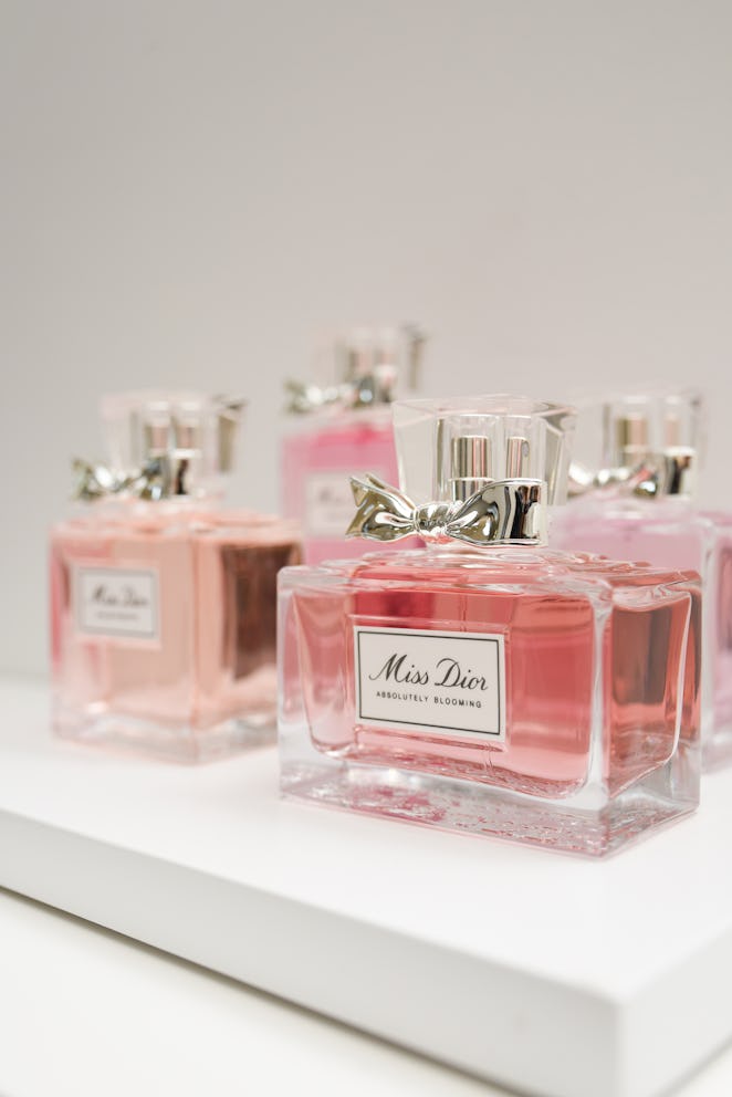 Miss Dior bottles on display, rose color perfume with little ribbons next to the cap.