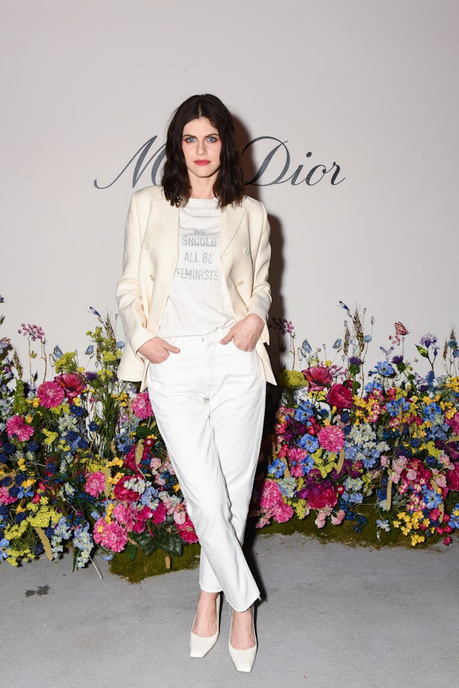 Alexandra Daddario dressed in white shades with a shirt that says "We should all be feminists".