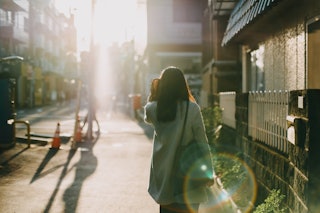 A woman walking on a sidewalk, enjoying her "Me Phase" 