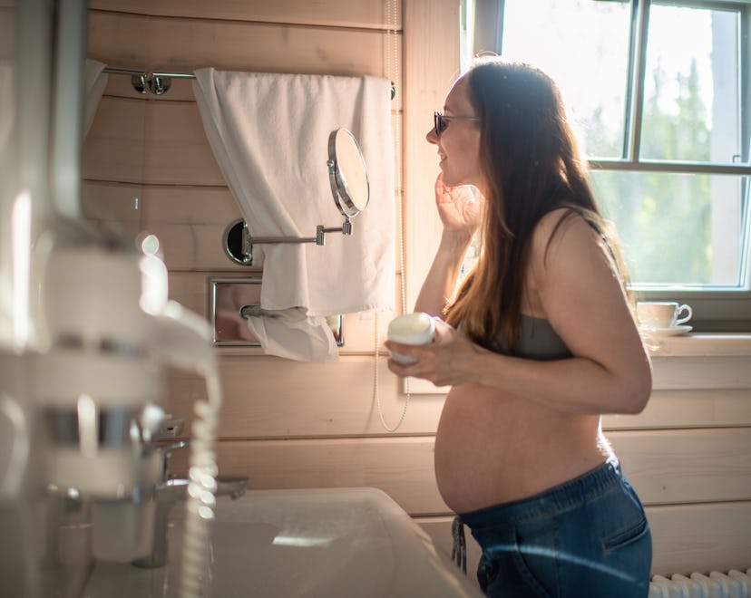 pregnant woman using face cream; experts explain the safety of using retinol and suggest alternative...