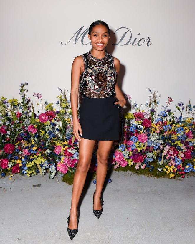 Yara Shahidi dressed in a transparent top with crystals and a lion print on it and a black skirt wit...