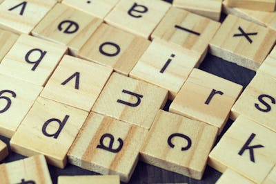 Alphabet letters on wooden scrabble pieces, close up