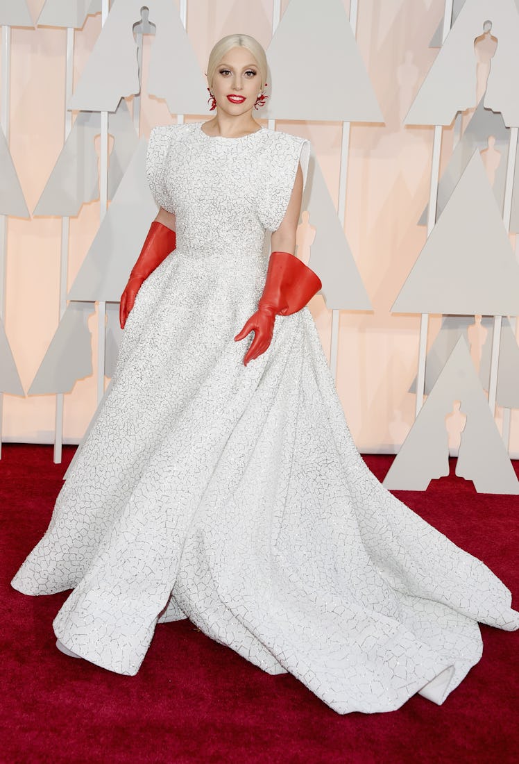 Lady Gaga wearing red gloves on the red carpet of the 2015 Oscars